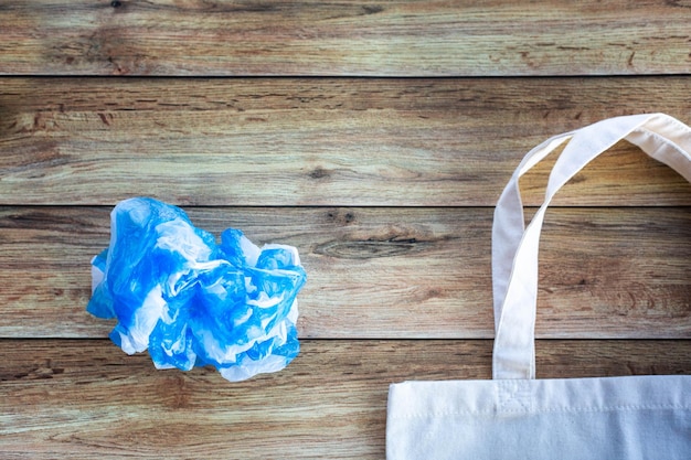 Photo sac à provisions écologique contre un sac en plastique sur fond de bois mise à plat sauver la planète terre