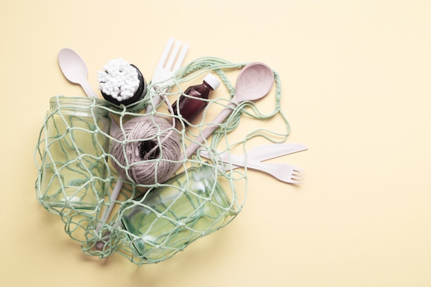 Photo sac à provisions en filet avec bocaux en verre et ustensiles de cuisine en bois