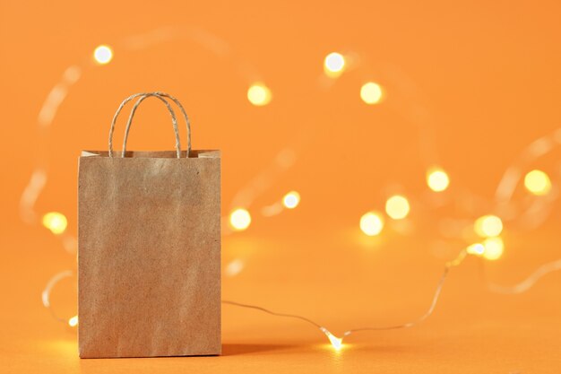 Un sac à provisions en papier sur fond orange. Le concept de livraison des achats et des ventes.Éblouissement en arrière-plan.