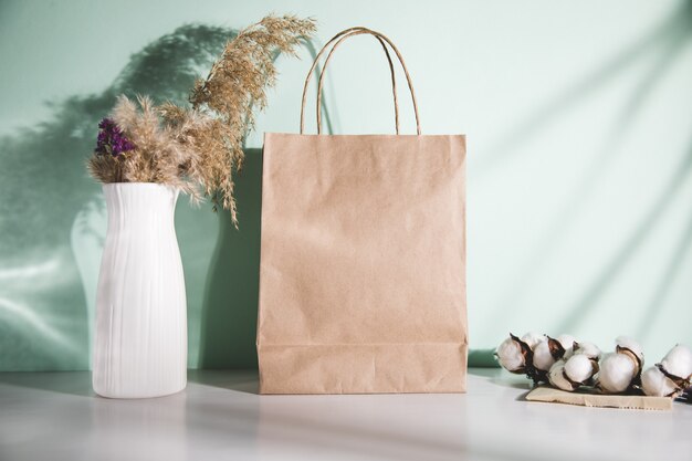 sac shopping avec coton et vase d'herbe