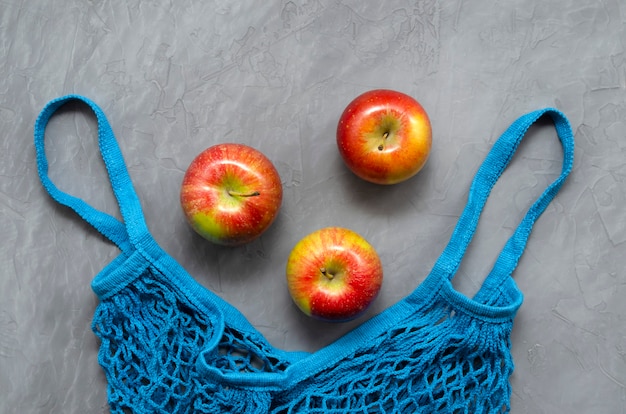 Sac shopping écologique zéro déchet en filet bleu avec pommes rouges aux fruits