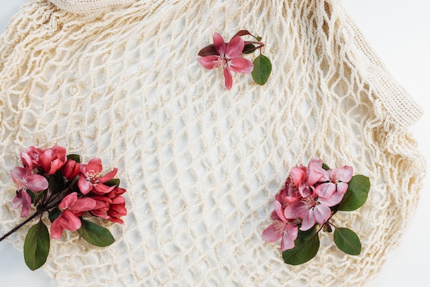 Sac shopping réutilisable en filet sur fond blanc avec fleurs Zéro déchet pas de plastique