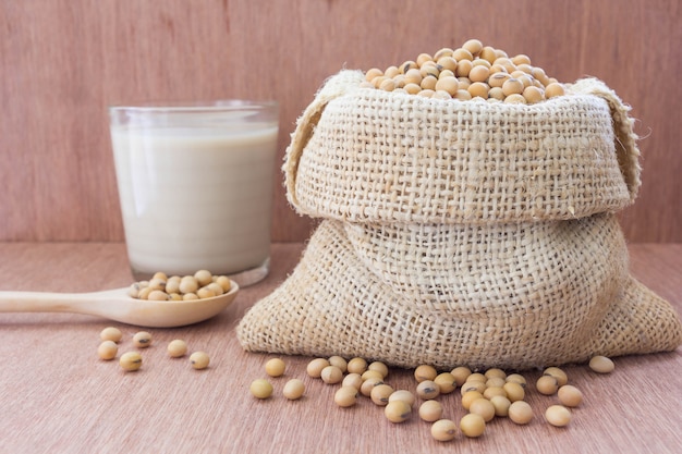 Sac de soja au chanvre avec du lait de soja en verre sur une table en bois