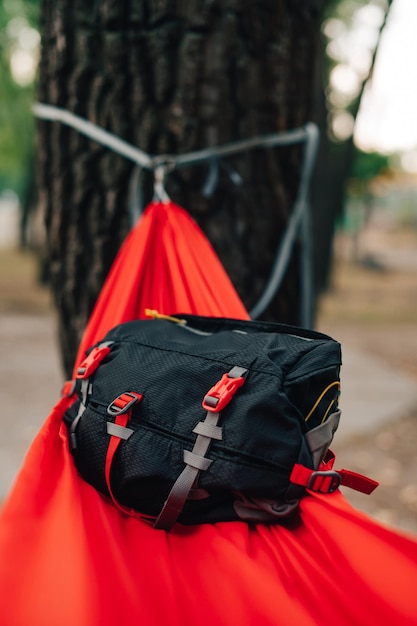 Le sac de taille de voyage se trouve sur un hamac dans les bois sur un fond de bois