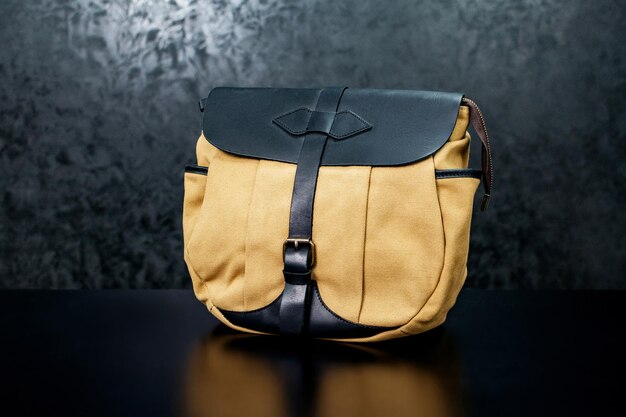 Photo sac en tissu jaune avec du cuir sur un fond sombre