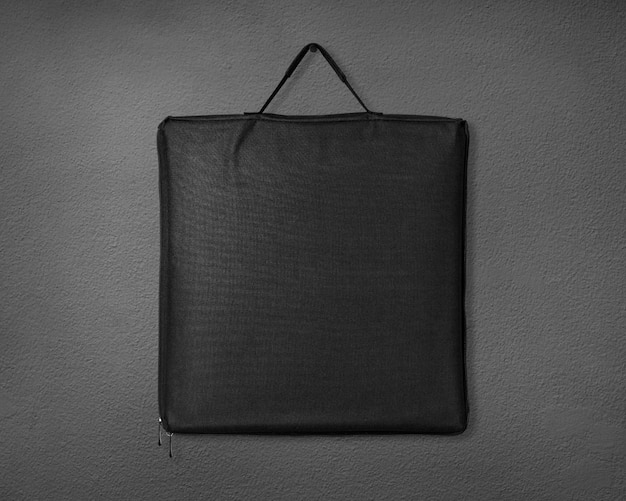 Sac en tissu noir sur fond de ciment.