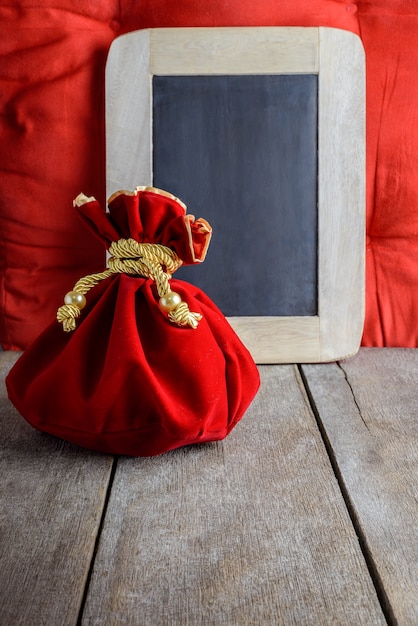 Photo sac en tissu ou en soie rouge du nouvel an chinois, poule de chance et tableau noir