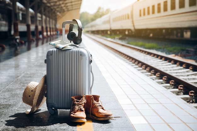 Sac de voyage, chapeau de paille, carte, écouteurs et bottes