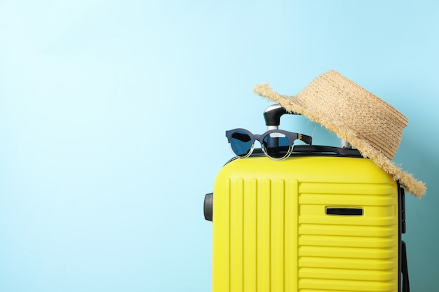 Sac de voyage avec lunettes de soleil et chapeau bleu