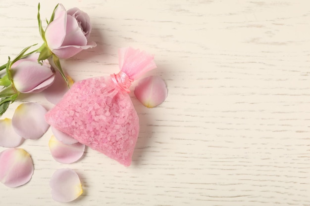 Sachet parfumé et roses sur une table en bois blanc mise à plat Espace pour le texte