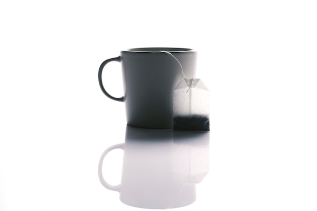 Sachet de thé et mug sur fond blanc