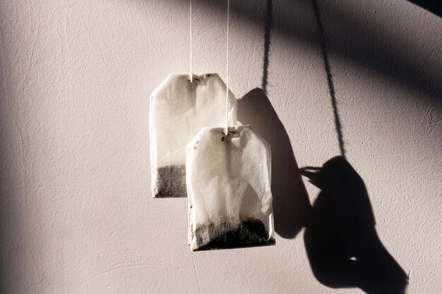 Sachets de thé avec une ombre sur un espace de copie de photo créative de fond de mur gris