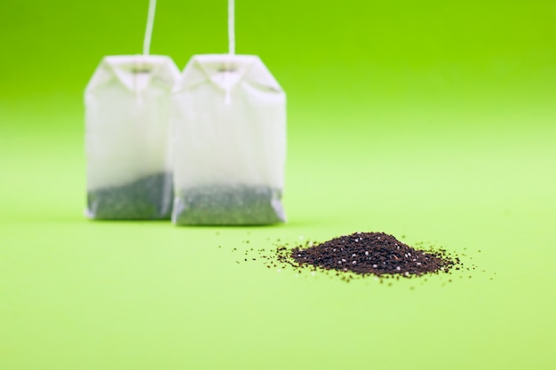 Sachets de thé à la saveur de citron sur une table verte.