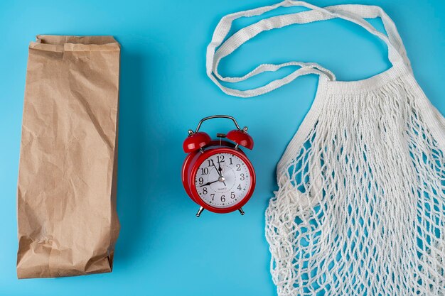 Sacs en coton, sac en filet. Sac en papier. Concept zéro déchet. Respectueux de la nature. Mise à plat avec une image de réveil rouge