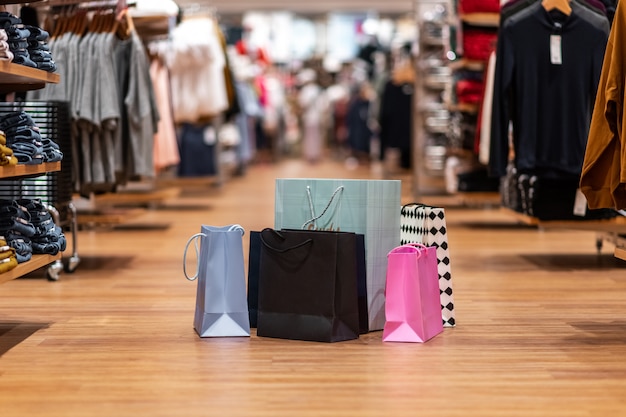 Photo des sacs de différentes couleurs et de différentes tailles se trouvent dans un même tas au milieu de la salle des marchés du magasin.