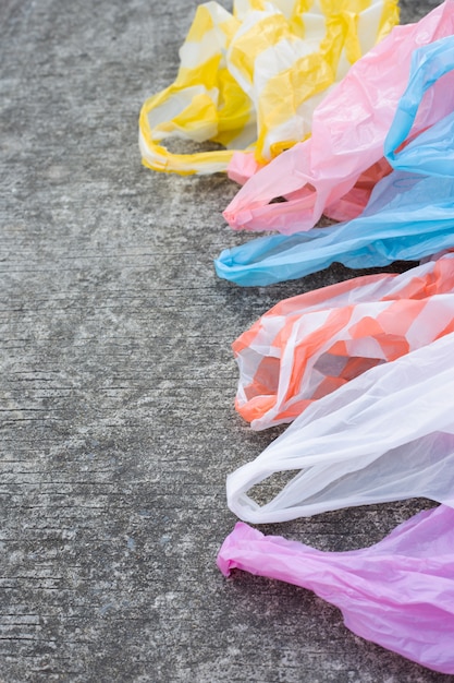 Sacs à ordures en plastique sur sol en ciment.