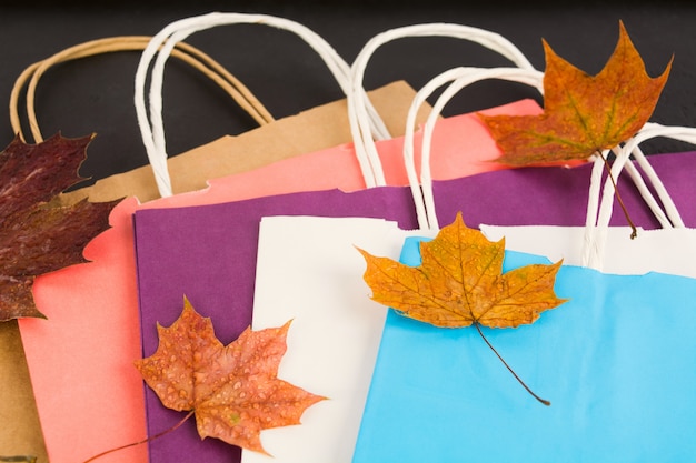 Photo sacs en papier colorés pour faire du shopping avec du feuillage d'automne