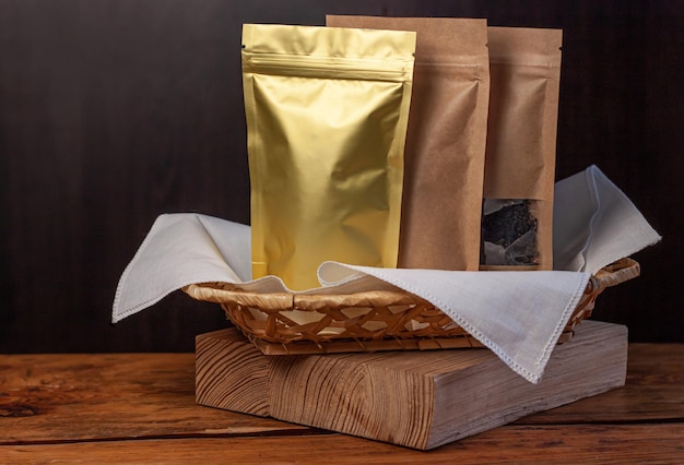 Photo sacs en papier et en feuille avec des grains de café et des feuilles de thé dans des paniers en osier pour produits alimentaires