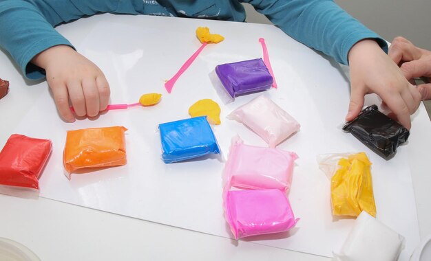 sacs de pâte à modeler et les mains des enfants sur un fond de tableau blanc