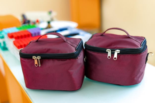 Sacs pour cosmétiques et bijoux. Trousses à cosmétiques en tissu marron foncé avec fermeture éclair. Deux sacs pour cosmétiques sur table avec arrière-plan flou.