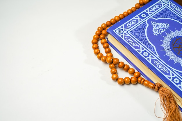 Le Saint Coran avec calligraphie arabe écrite chapelet ou tasbih sur fond blanc