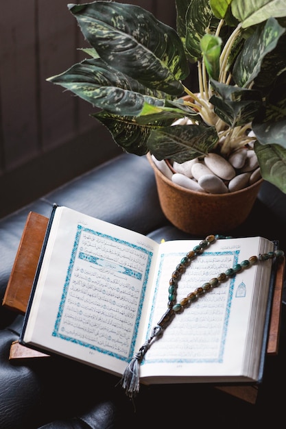 Le Saint Coran et le chapelet ou le tasbih sur un intérieur noir minimaliste