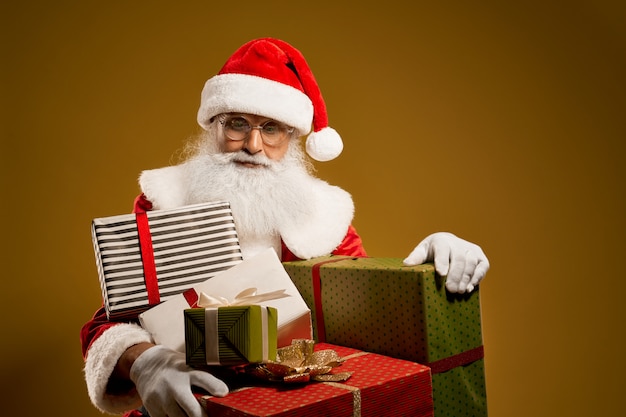 Saint Nicolas avec une vraie barbe portant des cadeaux aux enfants