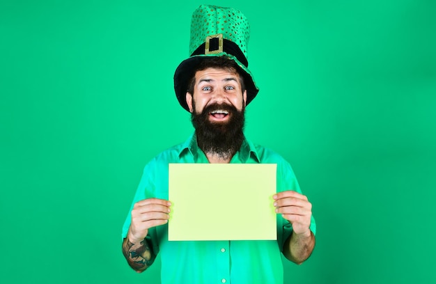 Saint patricks day heureux homme barbu au chapeau vert lutin avec panneau publicitaire homme habillé en