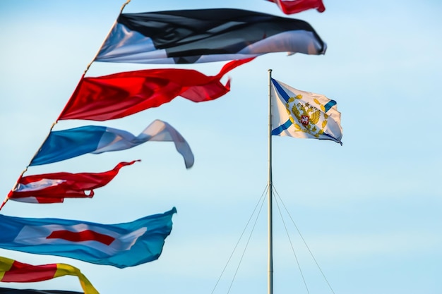 Photo saint-pétersbourg russie les drapeaux de signaux maritimes internationaux agitent sur le vent sous un ciel nuageux bleu