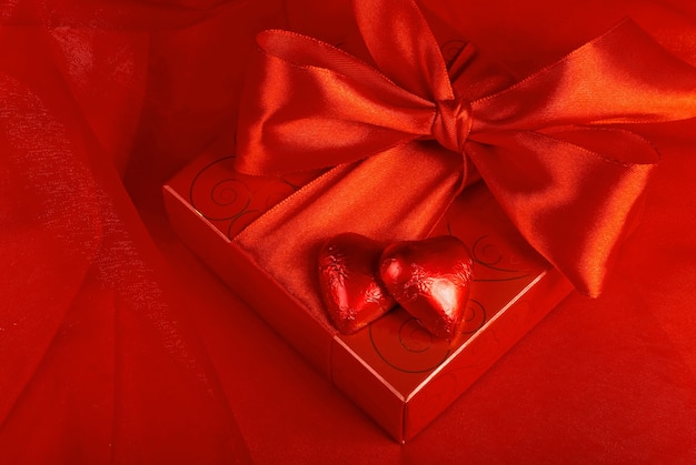 Photo la saint-valentin. bonbons cadeaux sous la forme d'un coeur sur fond rouge