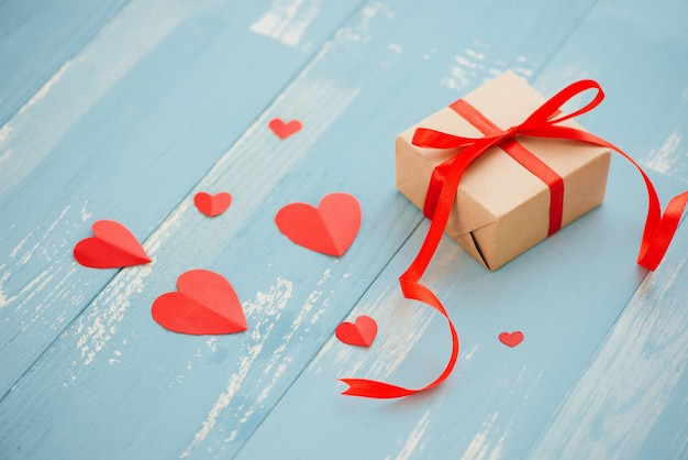La Saint-Valentin. Coffret cadeau, coeur de papier et confettis sur fond bleu vue de dessus