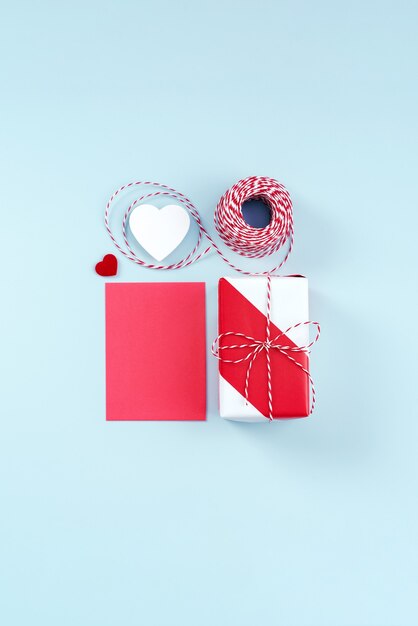 Saint Valentin, concept de design d'art de la fête des mères pour la promotion - Coffret cadeau emballé rouge et blanc isolé sur fond de couleur bleu clair pastel, mise à plat, vue de dessus.