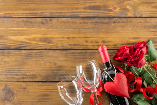 Saint Valentin décoration romantique avec des roses et du vin sur une table en bois marron