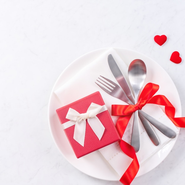 Saint-Valentin, fête des mères, repas de vacances, concept de design de banquet - Assiette blanche et ruban rouge sur fond de marbre, vue de dessus, mise à plat.