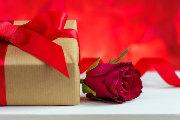 Saint Valentin fond rouge avec des roses et une boîte cadeau.