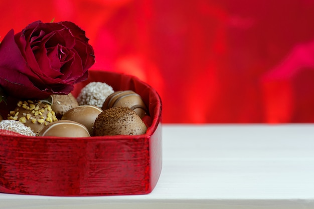 Saint Valentin fond rouge avec des roses et du chocolat.