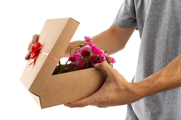 La Saint-Valentin. un homme ouvrant une boîte-cadeau pleine de fleurs.