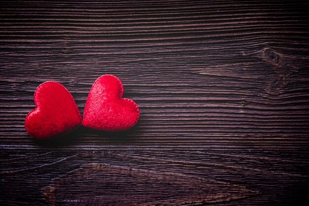 La Saint-Valentin. Oreiller cousu coeurs rouges pinces à linge sur les vieilles planches de bois, ton vintage.