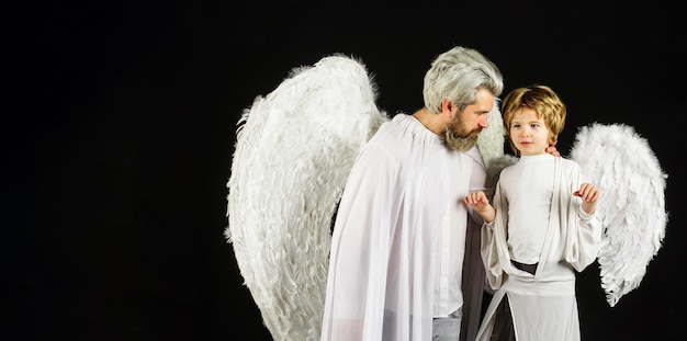 Saint valentin père et fils en ailes d'ange petit garçon cupidon et homme barbu en vêtements blancs