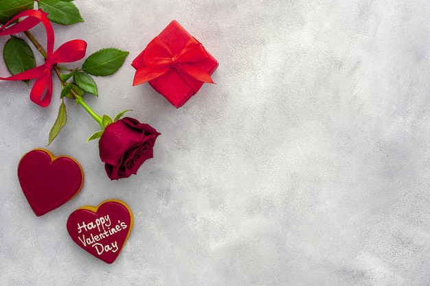 La Saint-Valentin. Rose rouge avec un ruban et une boîte rouge.