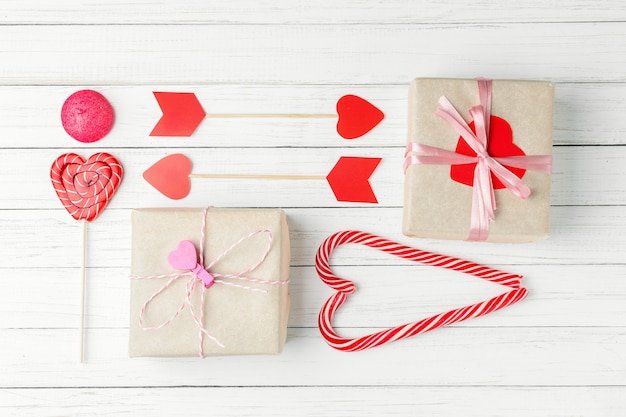 Saint Valentin sertie de bonbons, boîte cadeau et papier coupé coeur sur blanc