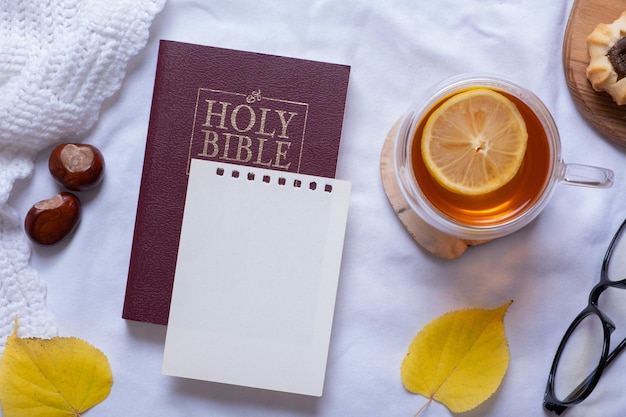 Sainte Bible et feuille de papier vierge avec vue de dessus d'un décor confortable d'automne Mise à plat d'automne