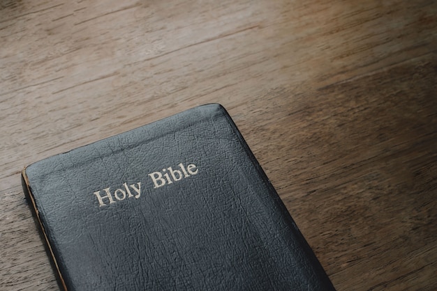 Sainte bible sur fond de table en bois avec lumière douce du soleil du matin concept de christianisme