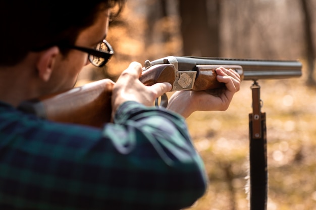 Saison de chasse d&#39;automne. Homme chasseur avec une arme à feu. Chasse dans les bois