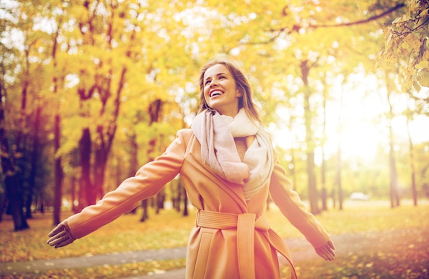 la saison et le concept des gens - belle jeune femme heureuse se promenant dans le parc d'automne