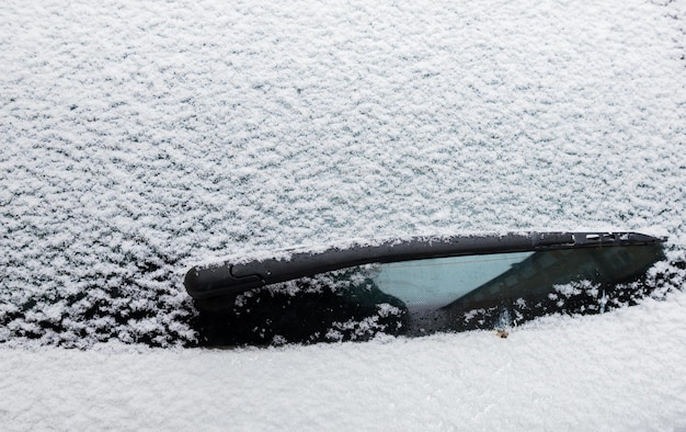 Saison d'hiver avec de la neige sur la voiture. Besoin de le nettoyer en vacances.