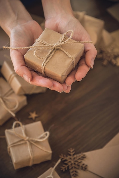 Photo saison de noël femme tenant un cadeau de noël dans ses mains