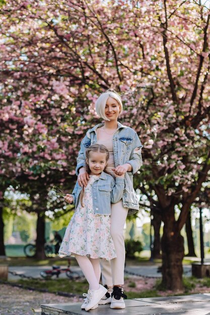 Sakura fleuri Une jeune mère avec son enfant s'amuse dans le parc près de la fleur de cerisier sakura