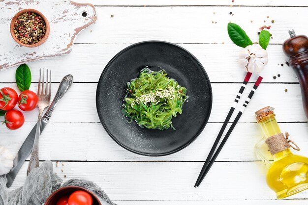 Salade d'algues dans une assiette noire Chuka wakame Sur le vieux fond Vue de dessus Espace libre pour votre texte