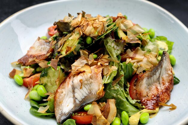 Salade d'anguille grillée et de légumes sur une assiette